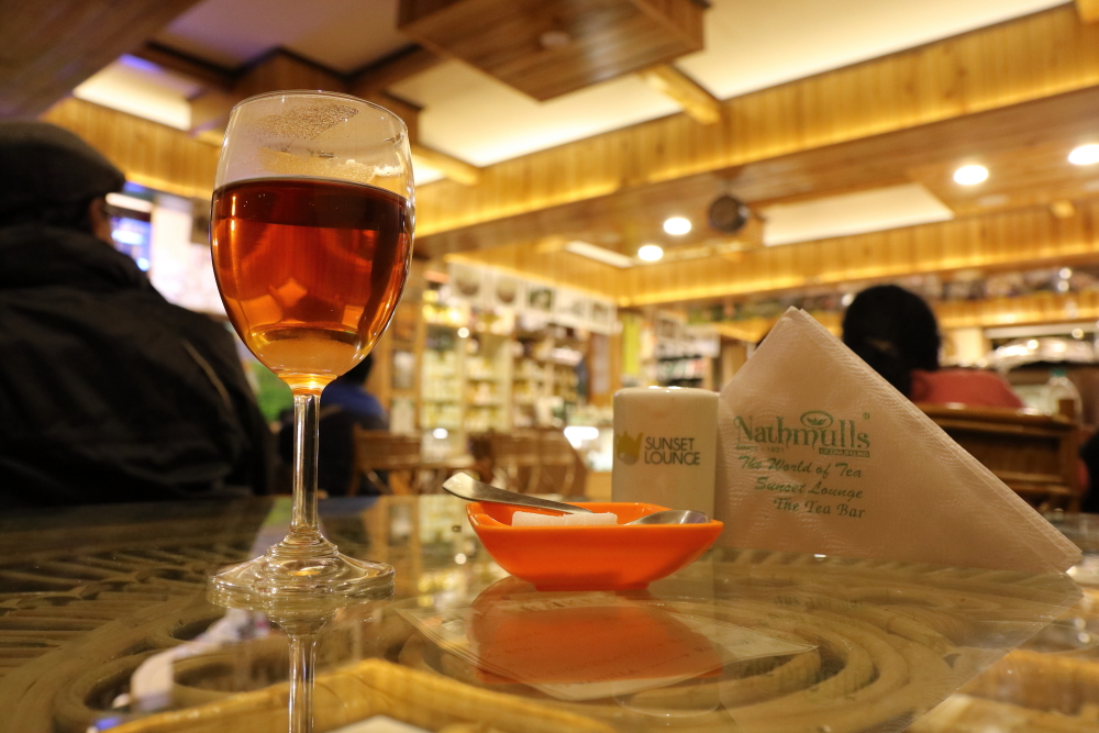 Champagne glass filled with Darjeeling tea inside Nathmull's Tea Lounge in Darjeeling