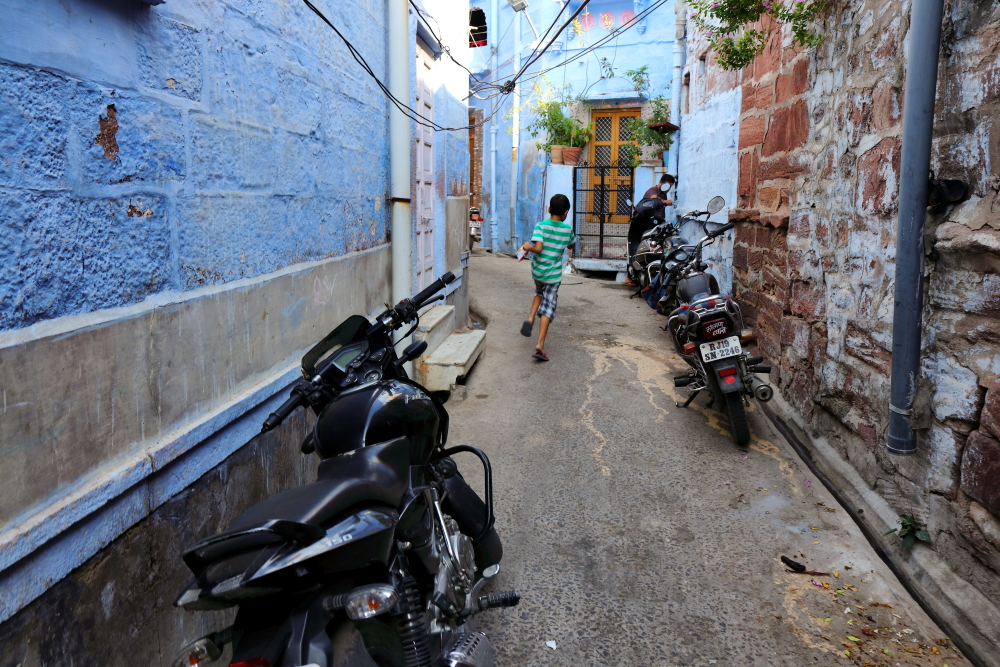 A boy running inside old lanes of blue city of Jodhpur.