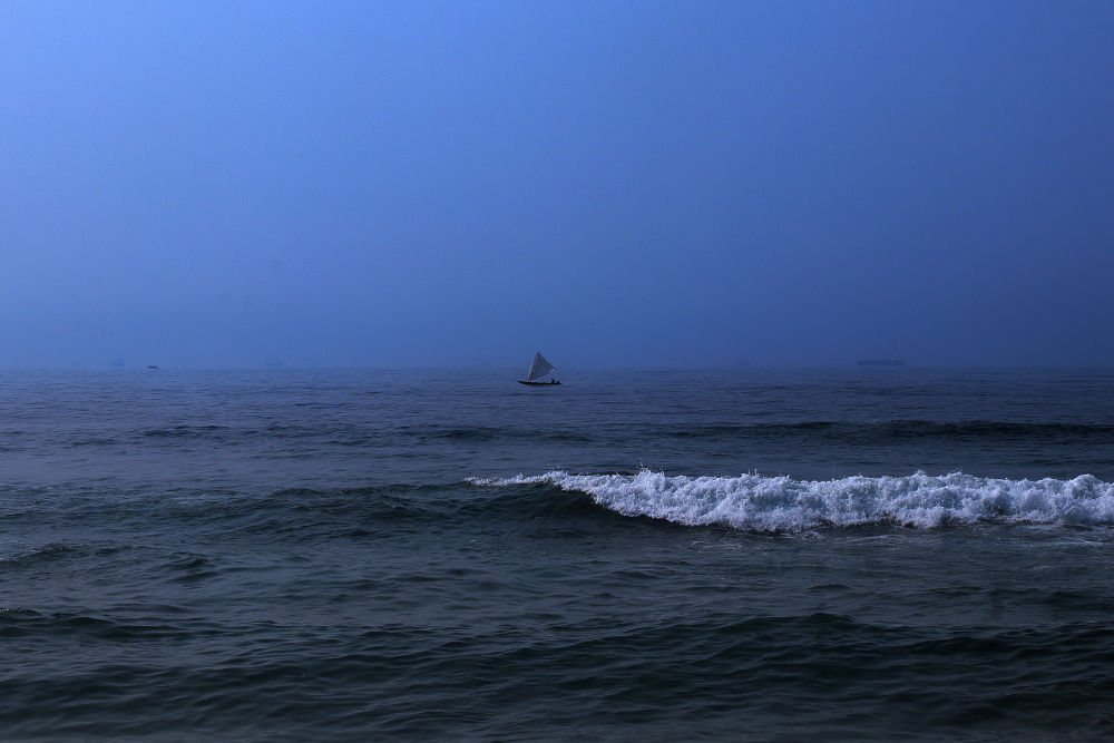 Image of a lonely sailing boat over Bay of Bengal in Vizag.