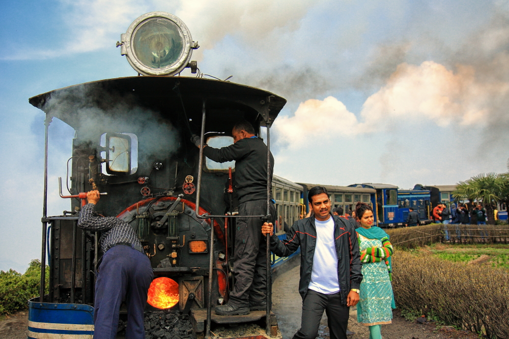Tourists busy in taking photos in front of Darjeeling Toy Train.